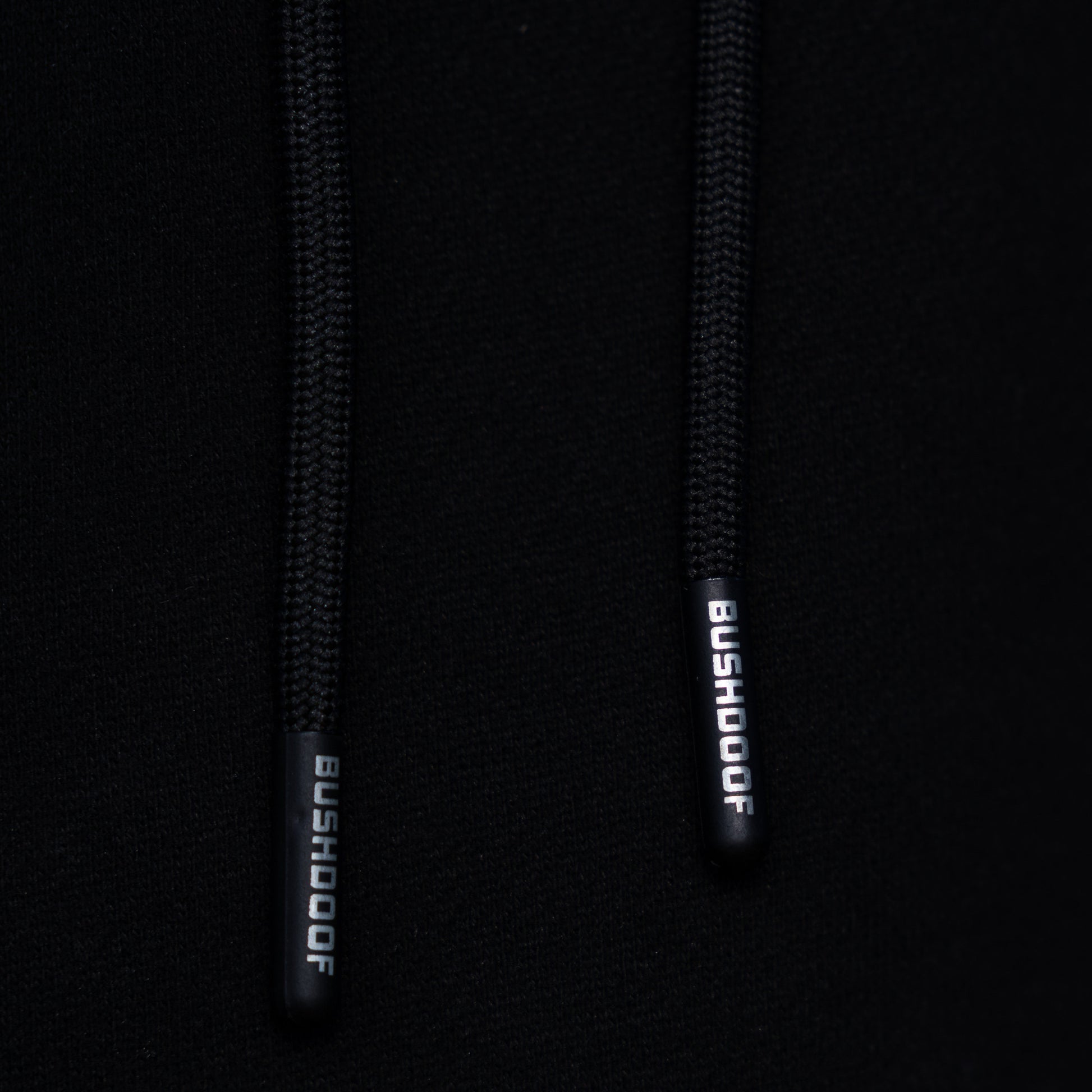 Bushdoof Staple Hoodie in black, worn outdoors