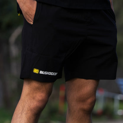Bushdoof Staple Shorts in black, worn outdoors