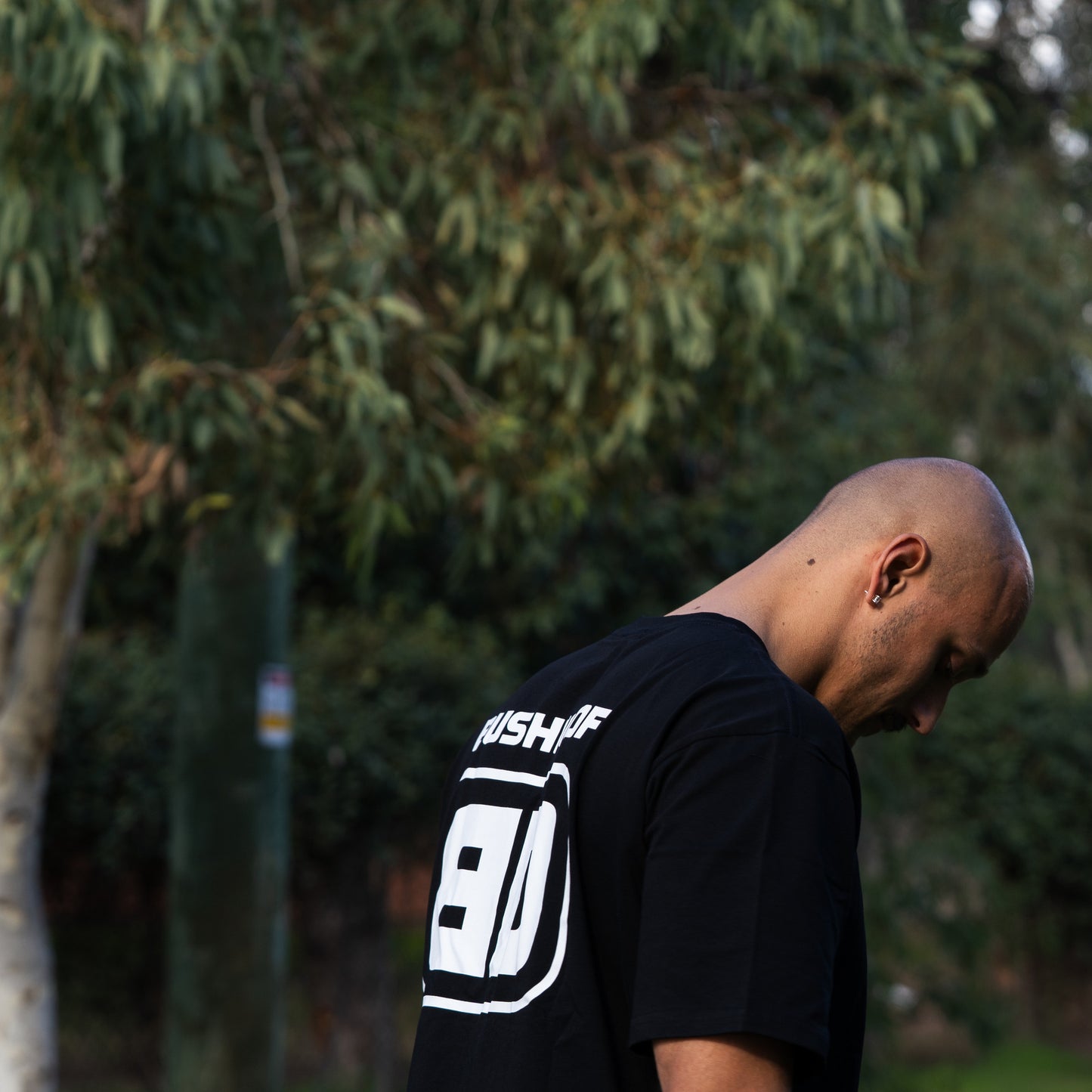 Bushdoof Staple Tee in black, worn outdoors