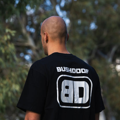 Bushdoof Staple Tee in black, worn outdoors