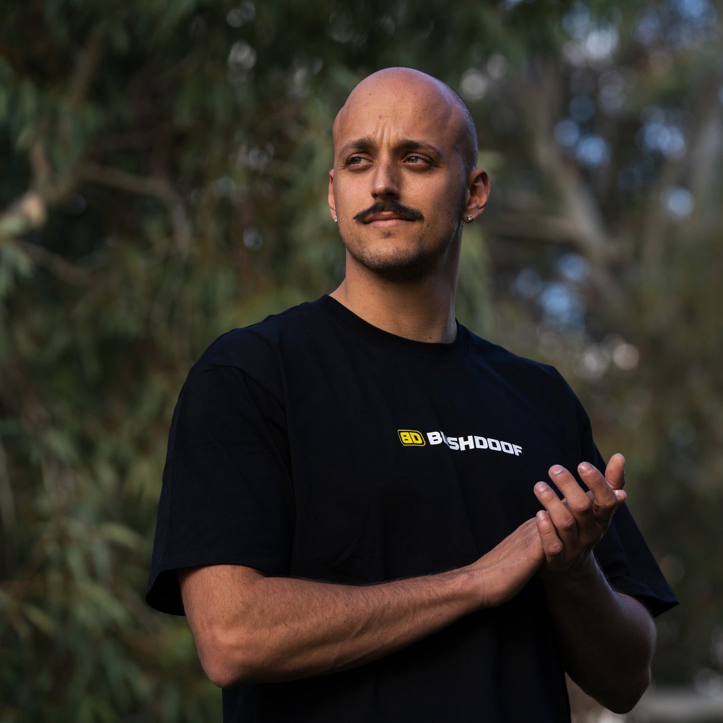 Bushdoof Staple Tee in black, worn outdoors